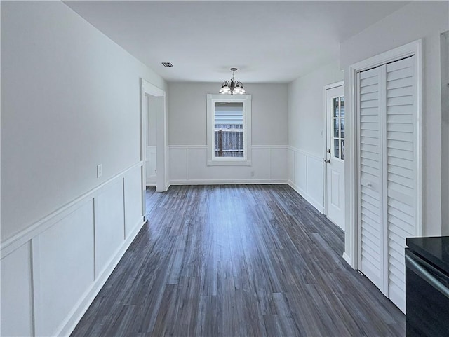 6042 Hugo Dr, Corpus Christi, TX 78412 - unfurnished dining area with a chandelier, dark wood-type flooring, a decorative wall, and a wainscoted wall