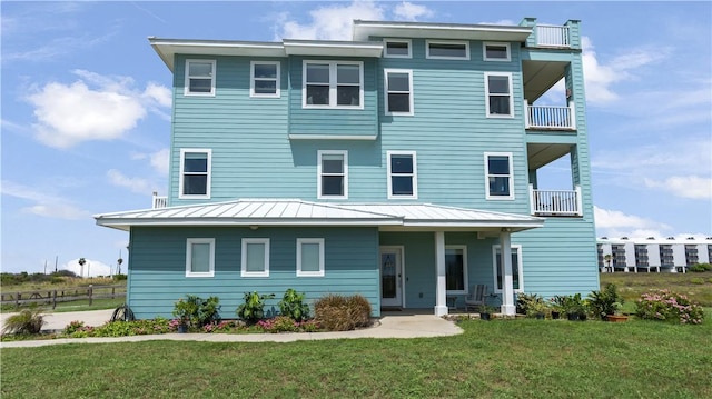 view of front facade with a balcony and a front lawn