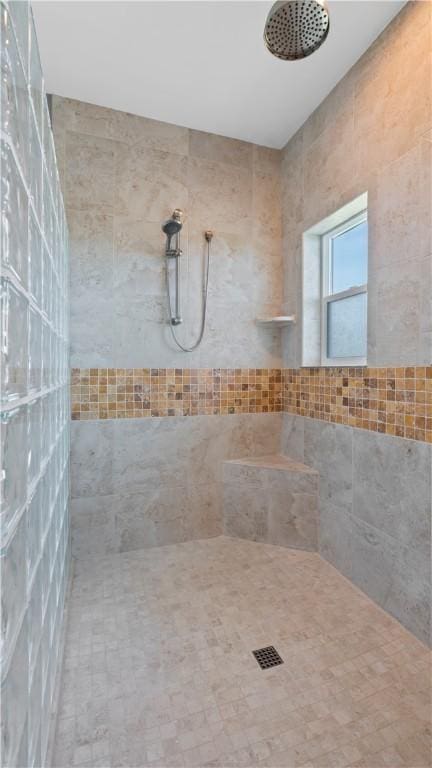 bathroom with a shower and tile walls