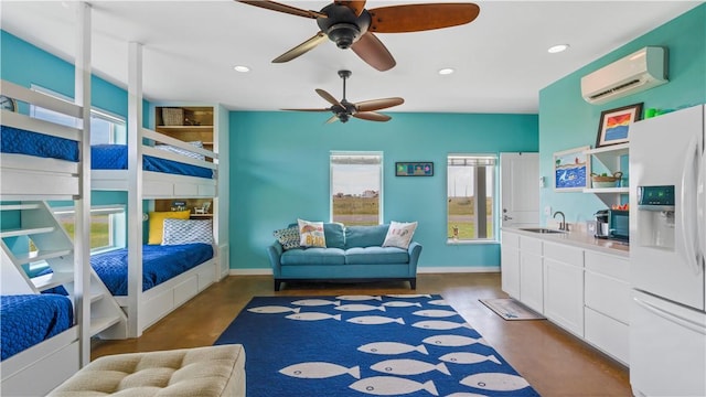 bedroom featuring white refrigerator with ice dispenser, a wall unit AC, multiple windows, and ceiling fan