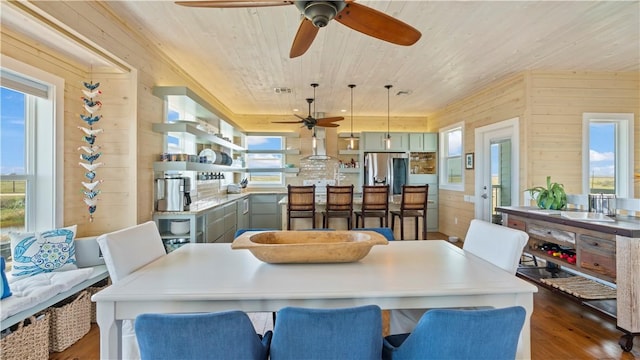 dining room featuring wood walls, wooden ceiling, and dark hardwood / wood-style floors