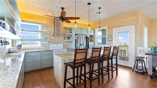 kitchen featuring white range with electric stovetop, light stone countertops, hardwood / wood-style floors, and a center island