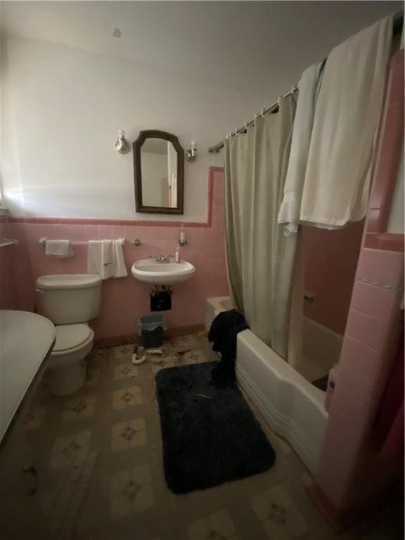 full bathroom featuring tile walls, sink, shower / bath combination with curtain, and toilet