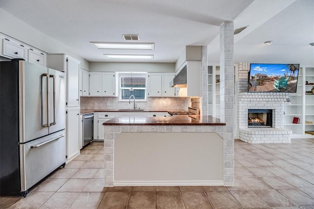 13810 Mizzen St, Corpus Christi, TX 78418 - kitchen featuring stainless steel appliances, a sink, a peninsula, white cabinetry, and backsplash