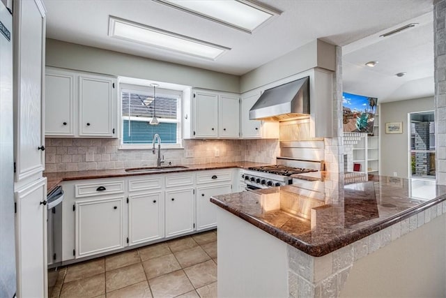 13810 Mizzen St, Corpus Christi, TX 78418 - kitchen featuring a sink, wall chimney range hood, a peninsula, decorative backsplash, and white cabinets