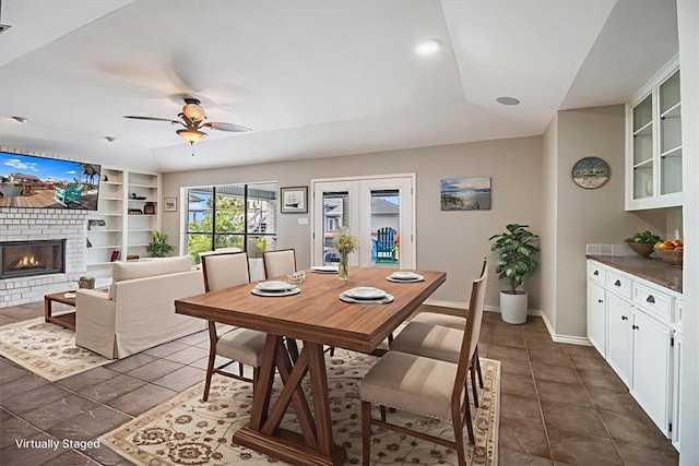 13810 Mizzen St, Corpus Christi, TX 78418 - dining space featuring built in features, ceiling fan, a fireplace, dark tile patterned floors, and baseboards