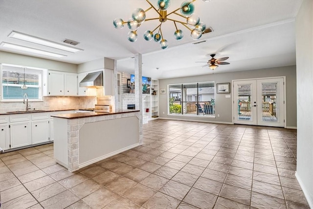 13810 Mizzen St, Corpus Christi, TX 78418 - kitchen with a sink, dark countertops, wall chimney exhaust hood, ceiling fan, and backsplash
