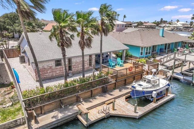 13810 Mizzen St, Corpus Christi, TX 78418 - rear view of house featuring a shingled roof, brick siding, central AC, boat lift, and a deck with water view