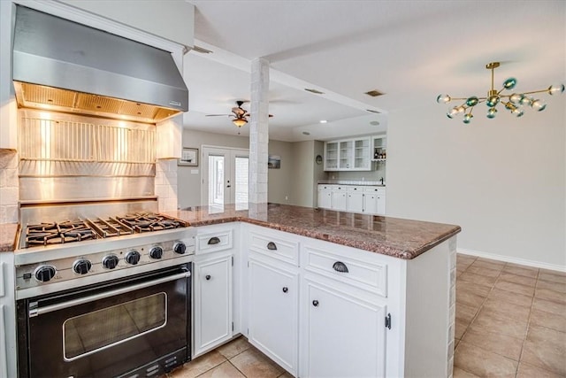 13810 Mizzen St, Corpus Christi, TX 78418 - kitchen featuring high end stove, wall chimney exhaust hood, a ceiling fan, light tile patterned floors, and white cabinetry