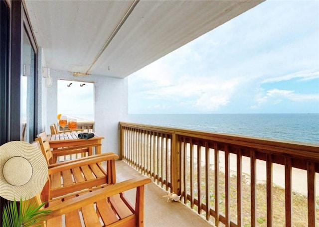 balcony featuring a water view and a beach view