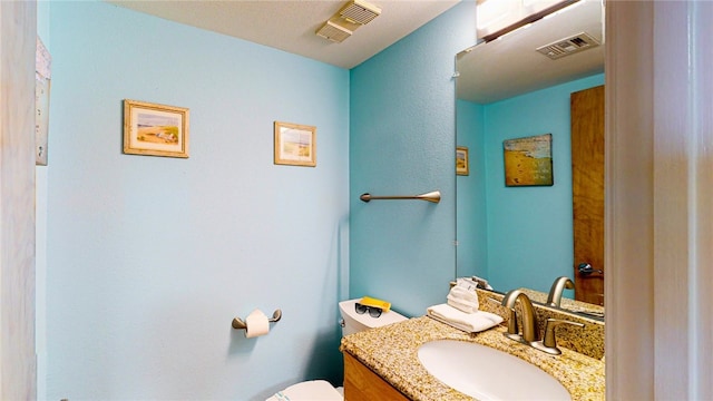 bathroom featuring toilet and vanity