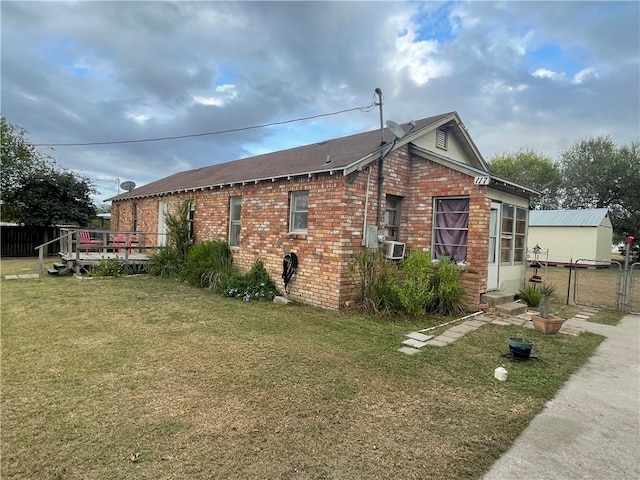 view of side of property with a lawn, a wooden deck, and cooling unit