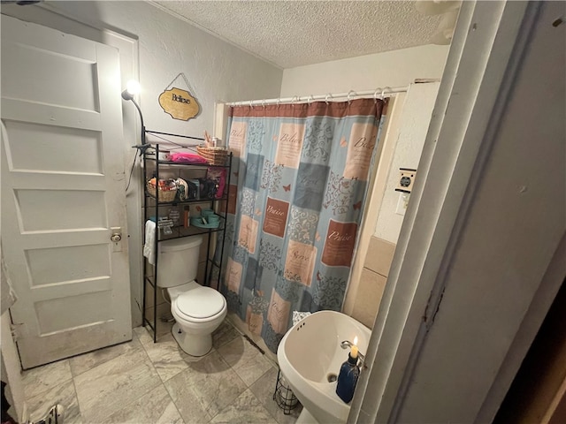 bathroom with a shower with shower curtain, a textured ceiling, and toilet