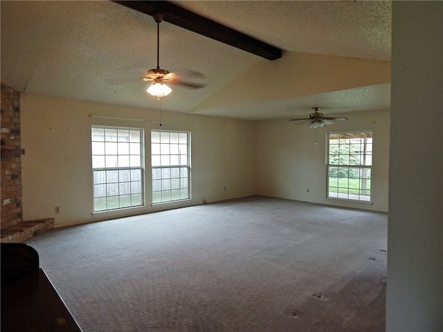 unfurnished living room featuring vaulted ceiling with beams, ceiling fan, carpet, and a textured ceiling