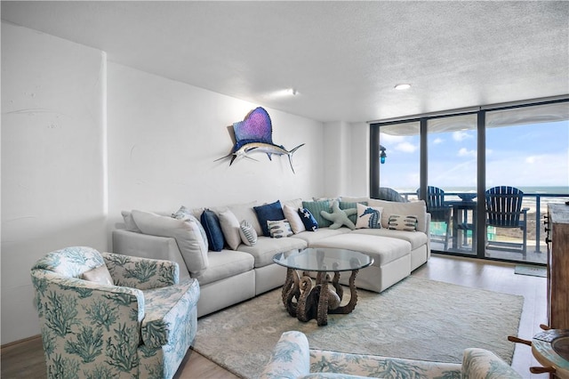 living area featuring expansive windows, a textured ceiling, and wood finished floors