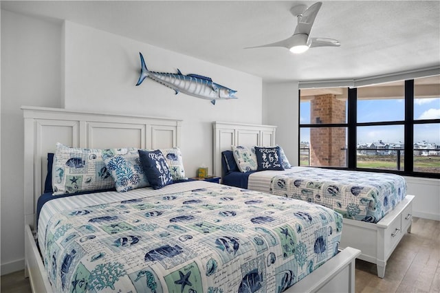 bedroom with a ceiling fan, baseboards, and light wood finished floors