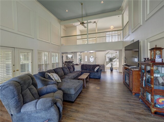 living room with a high ceiling, ceiling fan, and dark hardwood / wood-style floors