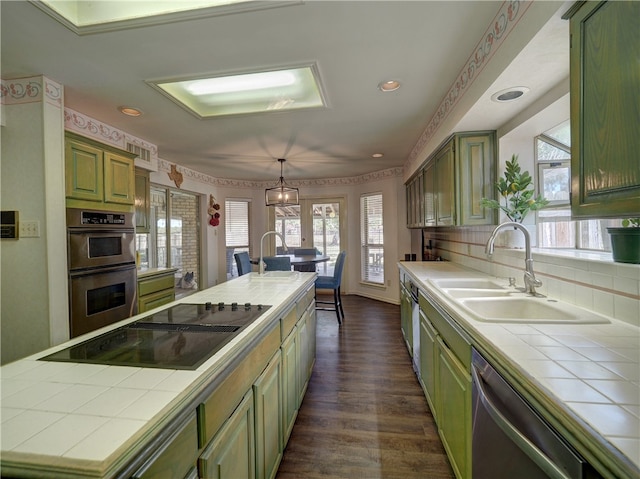 kitchen with tile counters, stainless steel appliances, sink, dark hardwood / wood-style floors, and backsplash