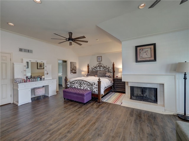 bedroom with ceiling fan, dark hardwood / wood-style floors, a tile fireplace, and ornamental molding