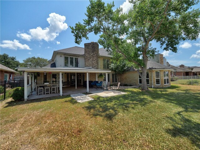 back of property featuring a patio and a yard