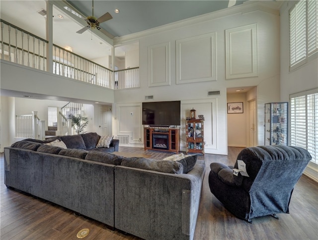 living room featuring dark hardwood / wood-style floors, a high ceiling, and ceiling fan