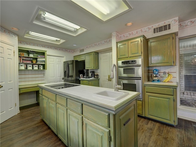 kitchen with dark hardwood / wood-style flooring, black appliances, sink, a kitchen island with sink, and backsplash