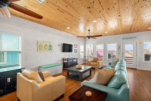living room with hardwood / wood-style floors, ceiling fan, wood walls, and wooden ceiling
