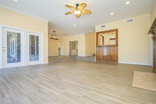505 Spyglass St, Rockport, TX 78382 - unfurnished living room with light wood-style floors, ceiling fan with notable chandelier, visible vents, and ornamental molding