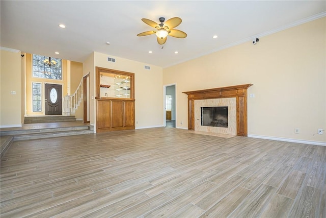 505 Spyglass St, Rockport, TX 78382 - unfurnished living room with ceiling fan with notable chandelier, light wood finished floors, a high end fireplace, and baseboards