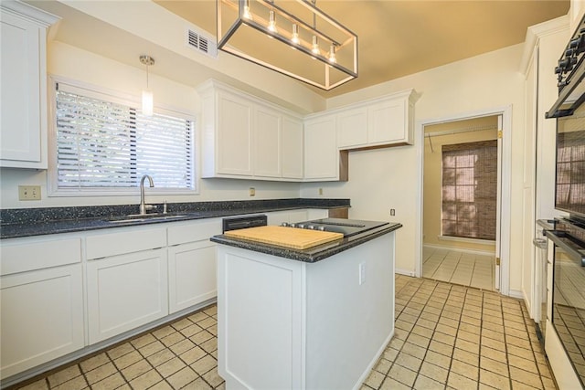 505 Spyglass St, Rockport, TX 78382 - kitchen featuring a kitchen island, decorative light fixtures, white cabinetry, stainless steel oven, and a sink