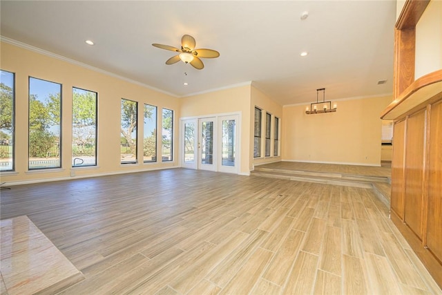 505 Spyglass St, Rockport, TX 78382 - unfurnished living room featuring light wood-style flooring, ceiling fan with notable chandelier, crown molding, and recessed lighting