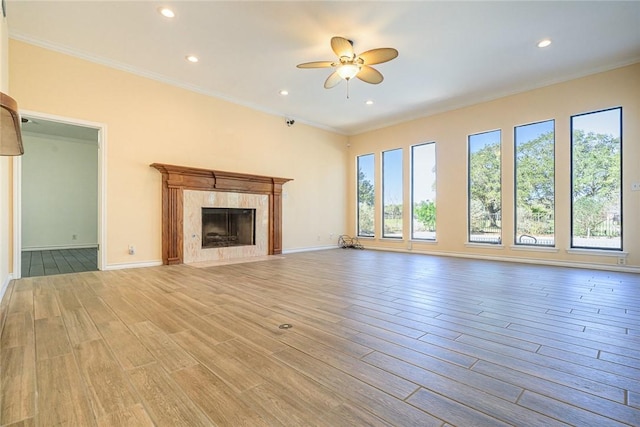 505 Spyglass St, Rockport, TX 78382 - unfurnished living room featuring light wood finished floors, baseboards, a ceiling fan, ornamental molding, and a high end fireplace