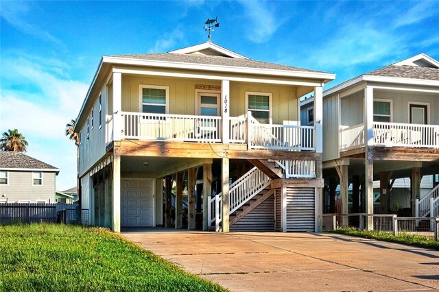 view of front of property with a carport, covered porch, an attached garage, concrete driveway, and stairs