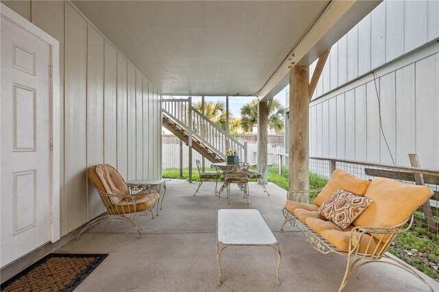 view of patio featuring stairway and fence