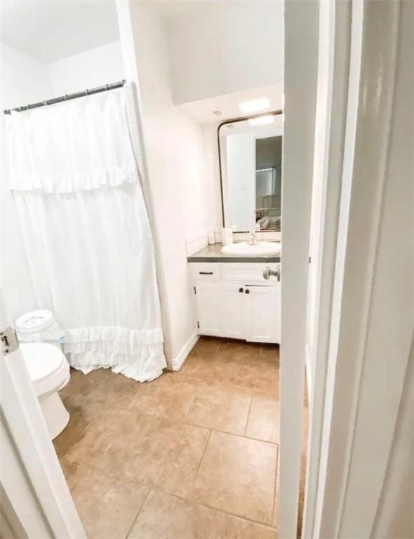 1801 Clare Dr, Alice, TX 78332 - bathroom with vanity, toilet, tile patterned flooring, a shower with shower curtain, and baseboards
