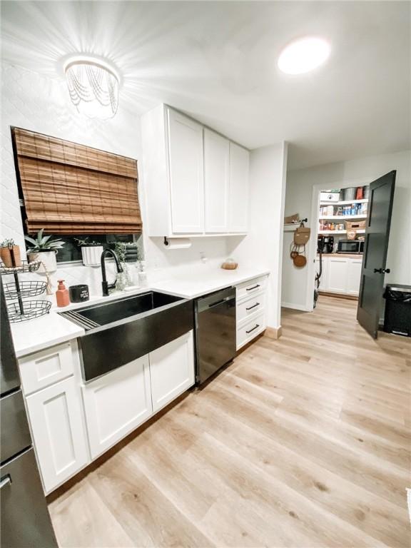 1801 Clare Dr, Alice, TX 78332 - kitchen with dishwasher, a sink, light countertops, and white cabinets