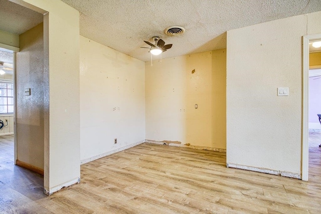 spare room with ceiling fan, a textured ceiling, and light wood-type flooring