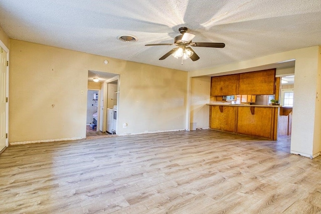 kitchen featuring light wood-type flooring, kitchen peninsula, a textured ceiling, and ceiling fan