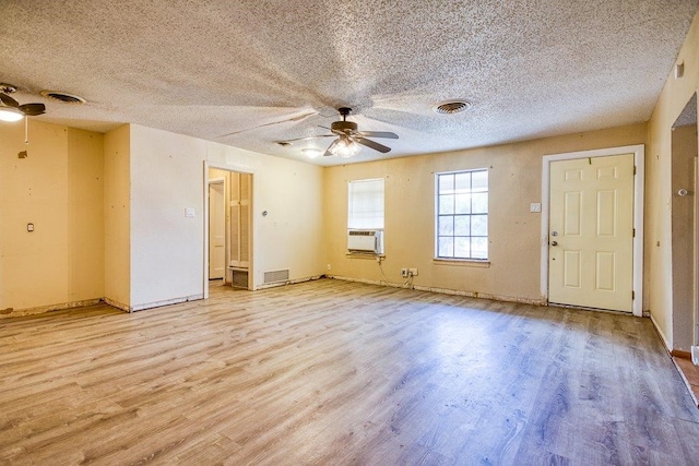 empty room with a textured ceiling, ceiling fan, and light hardwood / wood-style flooring