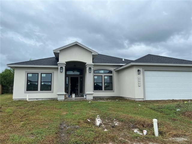 view of front of home with a garage and a front lawn