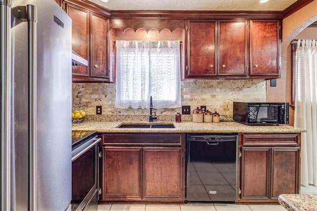 kitchen with light stone counters, sink, backsplash, and black appliances