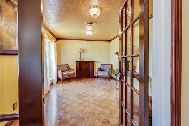 sitting room featuring a textured ceiling, ornamental molding, french doors, and light parquet flooring