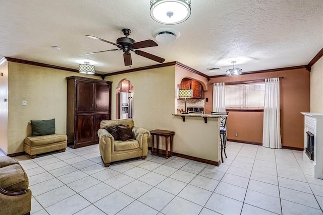 tiled living room with crown molding, ceiling fan, and a textured ceiling