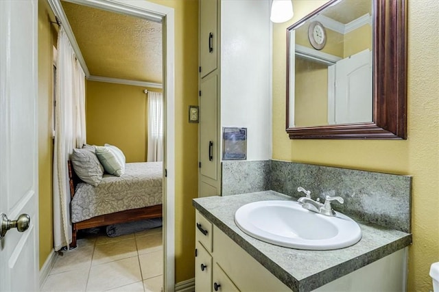 bathroom with crown molding, vanity, tile patterned flooring, and a textured ceiling