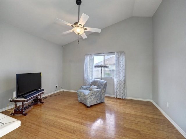 sitting room with baseboards, ceiling fan, wood finished floors, and high vaulted ceiling
