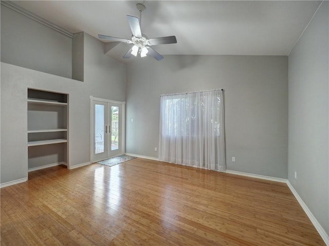 empty room featuring ceiling fan, built in features, french doors, baseboards, and wood finished floors