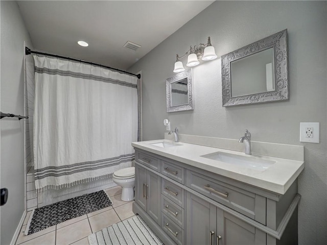 full bathroom with double vanity, toilet, visible vents, and a sink