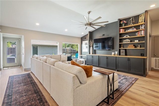 living room with lofted ceiling, recessed lighting, light wood-style floors, and ceiling fan