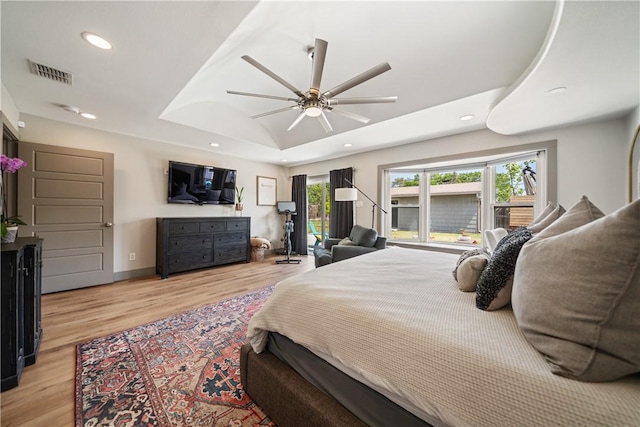 bedroom featuring recessed lighting, light wood-style flooring, visible vents, and a raised ceiling
