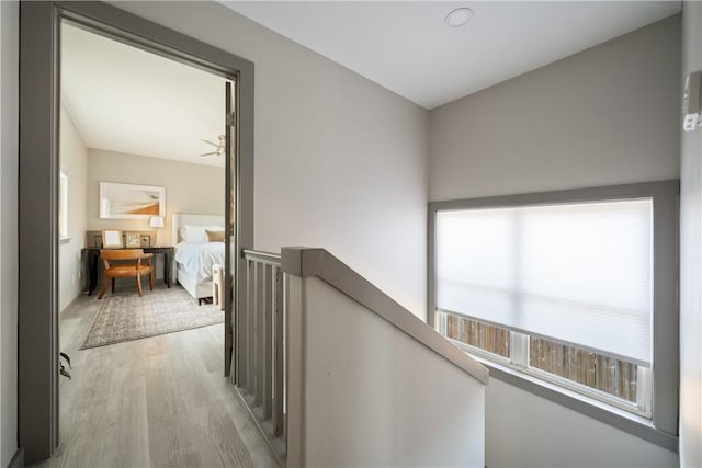 hall featuring wood finished floors and an upstairs landing
